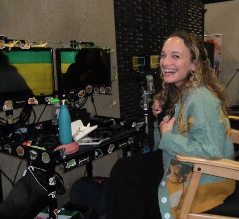 Director Ella Jones smiles at the camera from by her monitor