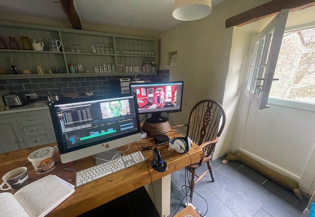 Two screens on a kitchen table - an ad hoc editing station, with light coming through the stable door on the right