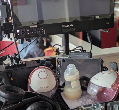 A baby bottle and breast pumps sit by the director's monitor